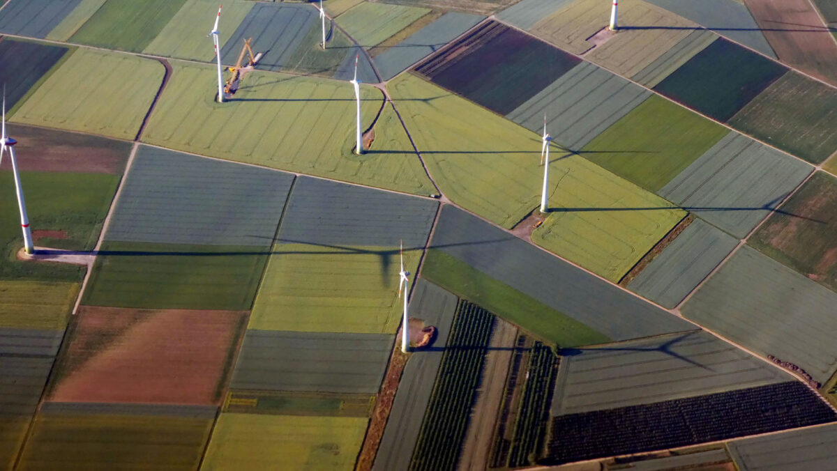 Flygfoto av landskap med åkrar och vindkraftverk